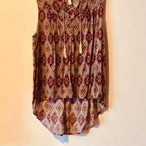 Sleeveless shirt,front cross tie with decorative tassel,longer back. Size XL